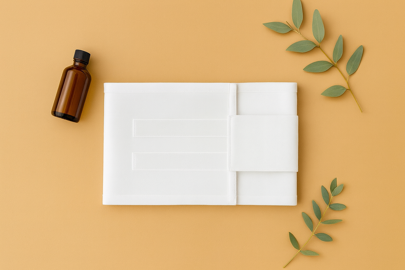 Brown bottle, white folded towel, and green leaves on a beige background.